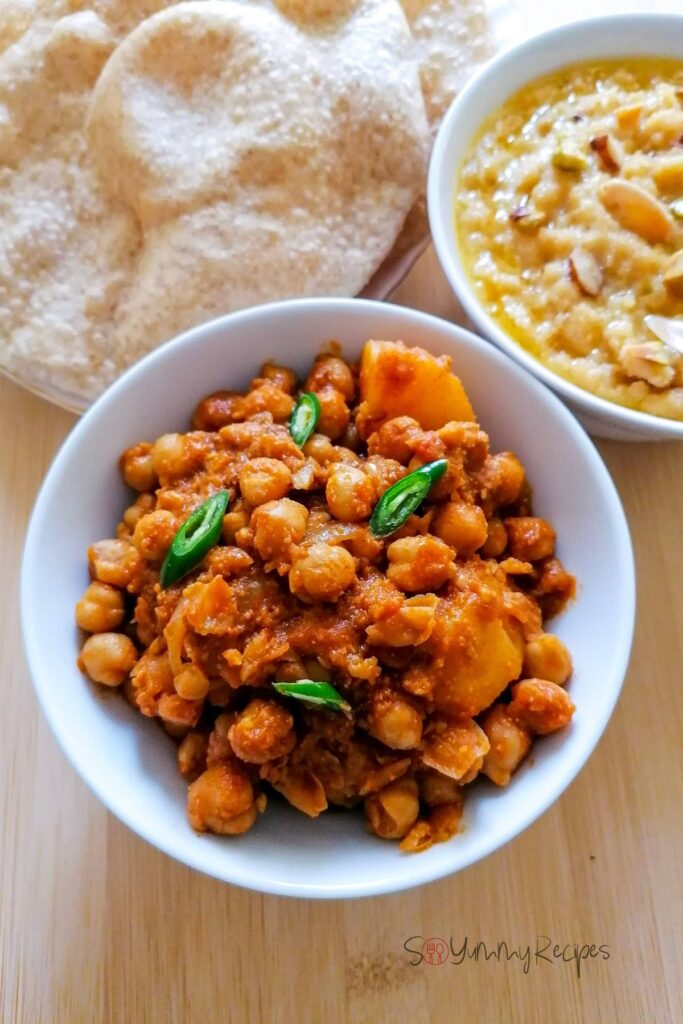 Pakistani style of chickpea and potato curry in a white bowl.