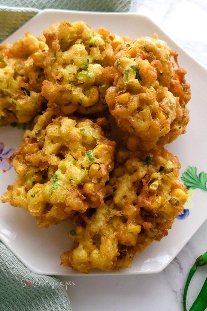 Sweetcorn fritters on a white hexagon plate.