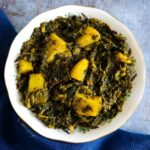 Aloo Palak the potato and spinach curry in a small white bowl.