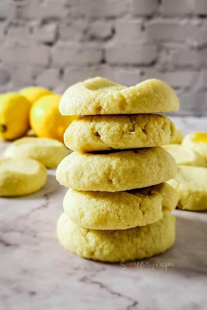 Five shortbread cookies with lemon flavor stacked together.