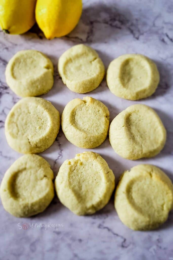Shortbread cookies with lemon on marble worktop.