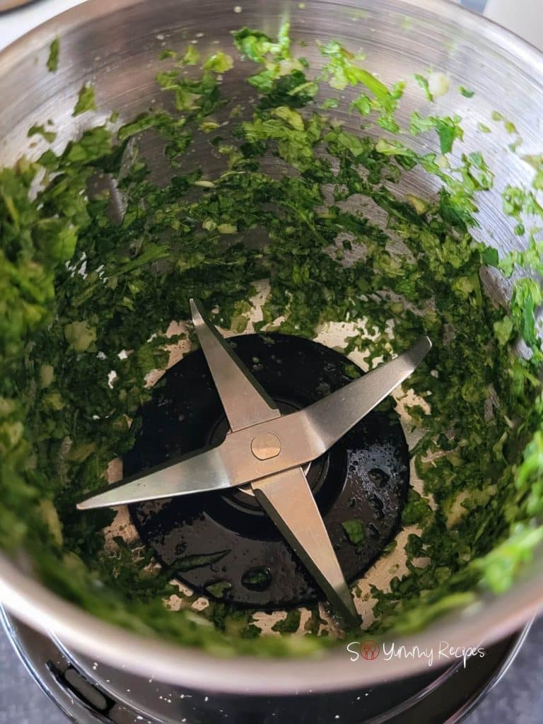 Chopped mint leaves and cilantro in a mini chopper.