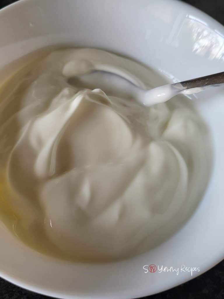 Yogurt in a white bowl with a spoon. 