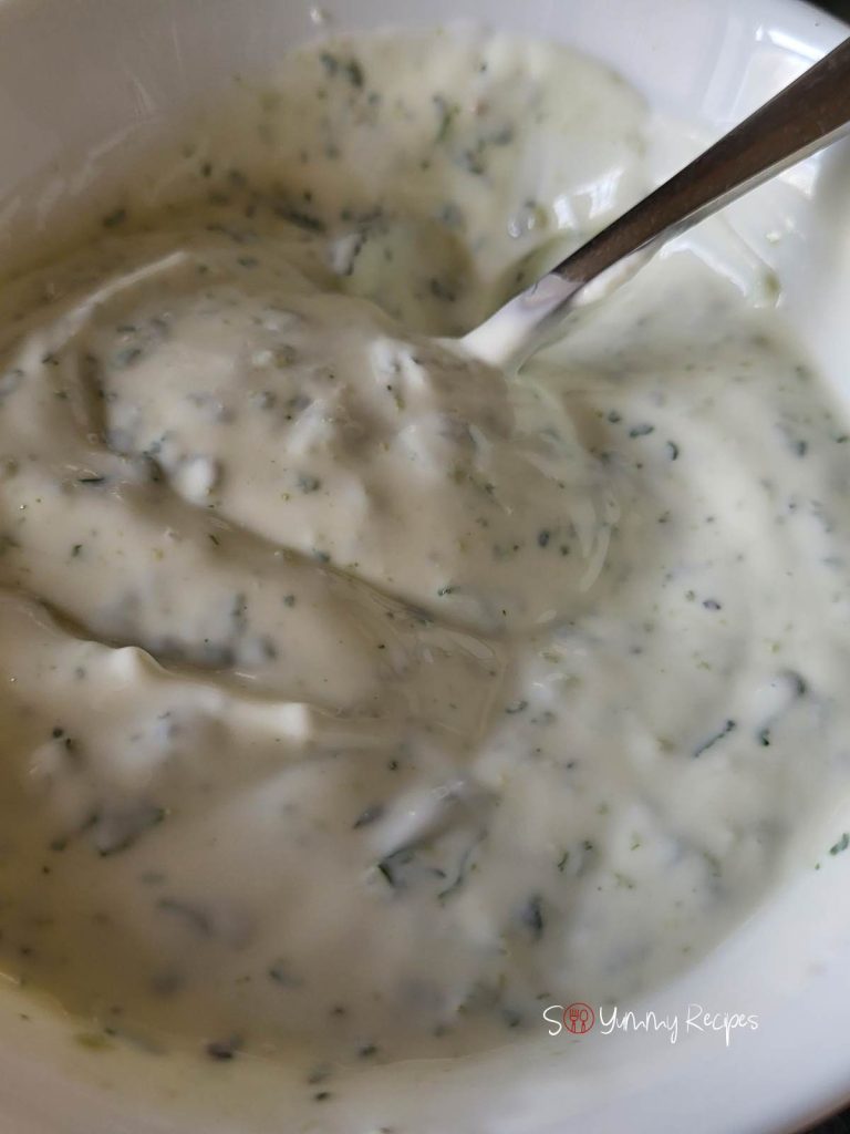Mint yogurt chutney and a spoon in it.