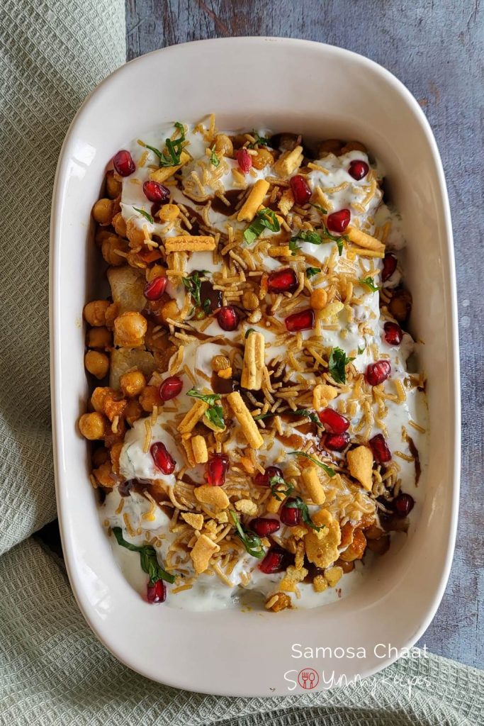 Spicy and savoury snack made of samosa, chickpea, yogurt, tamarind and garnished with fine sevian and pomegranate.