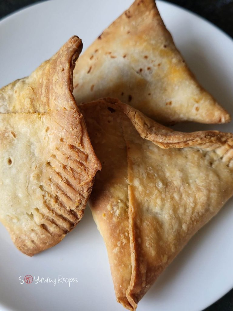 3 samosas on a white plate.