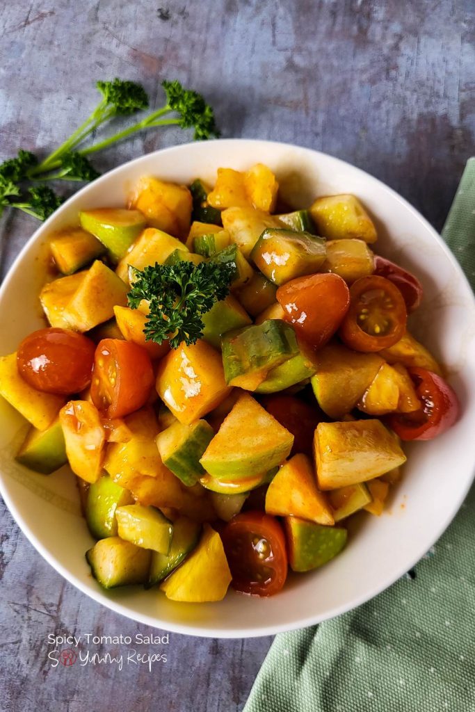 Spicy tomato salad garnished with curly parsley.