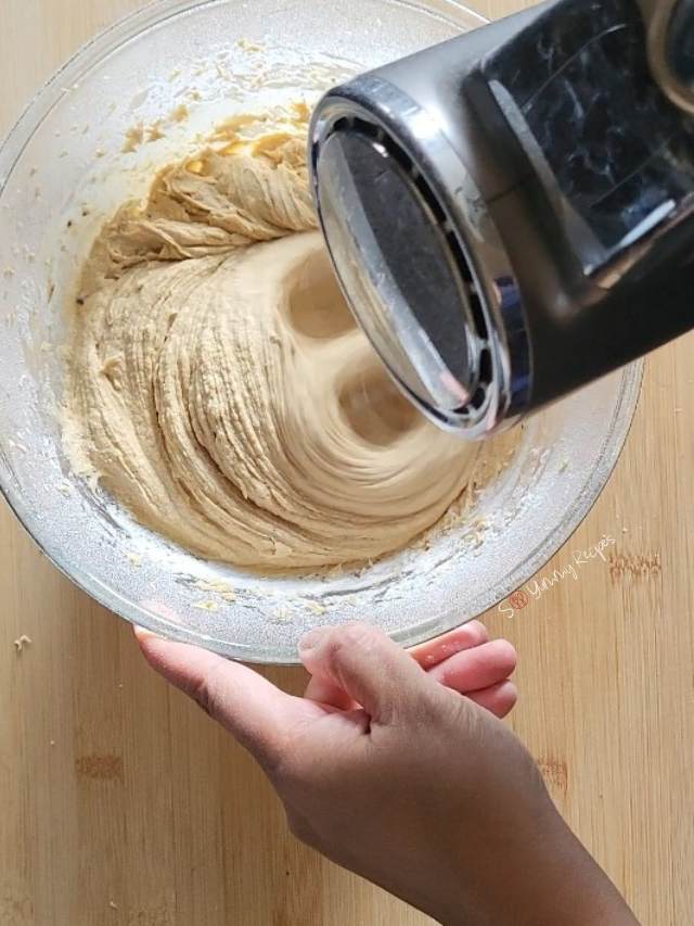 mixing cupcake batter with handheld mixer.