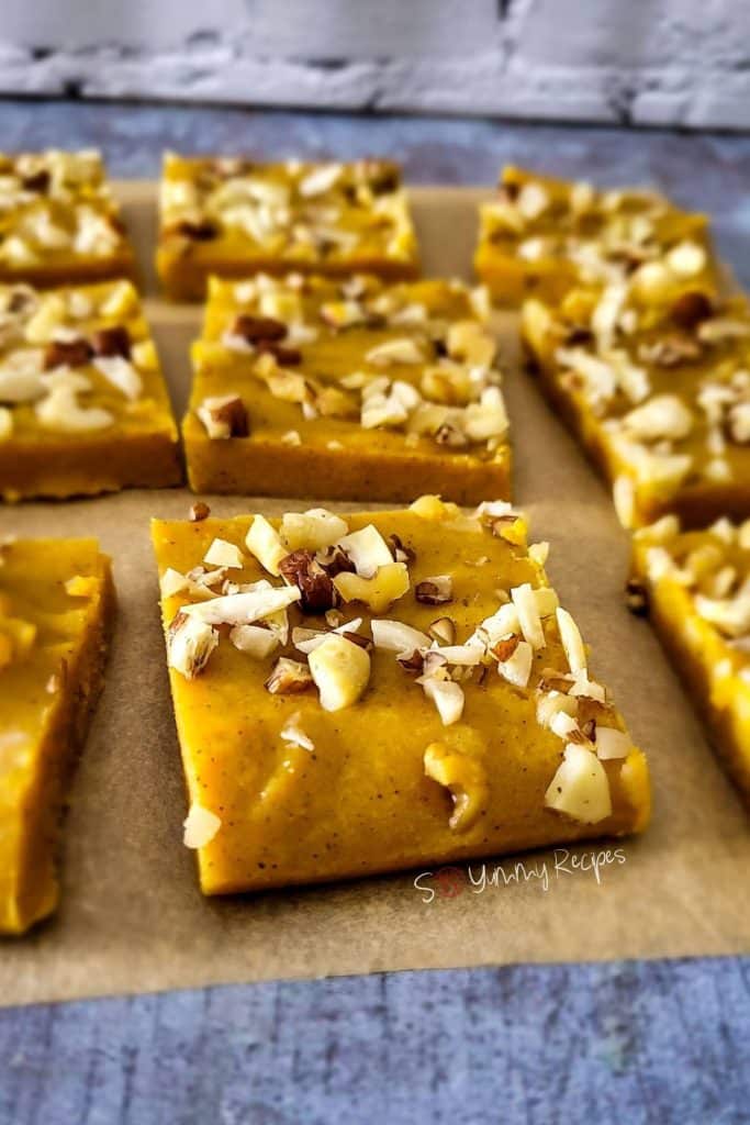 Sweet fudge made with pumpkin sweetened condensed milk and topped with chopped nuts.