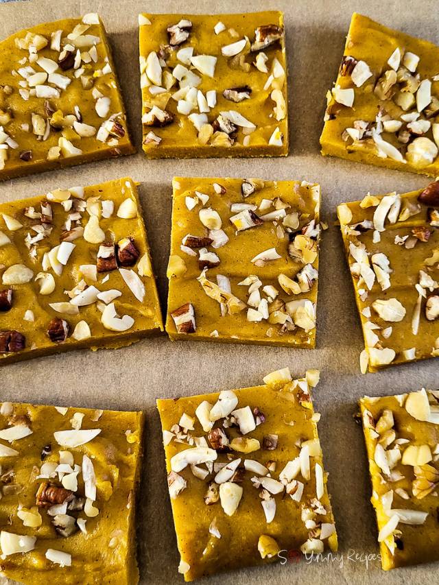 Squares of pumpkin fudge on a chopping board.