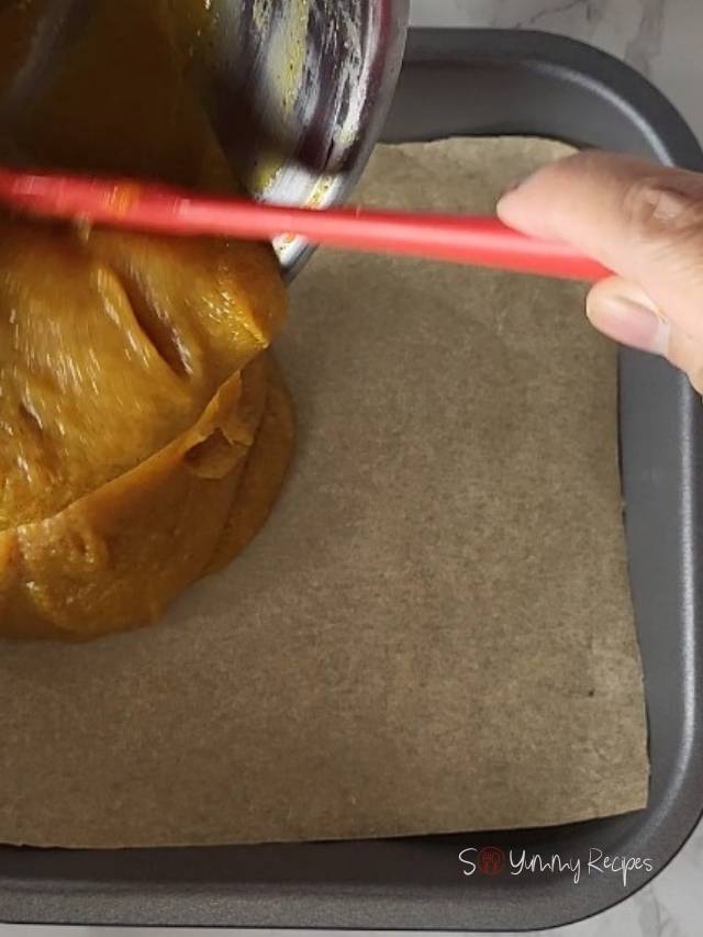 Pouring fudge mixture onto a baking pan.