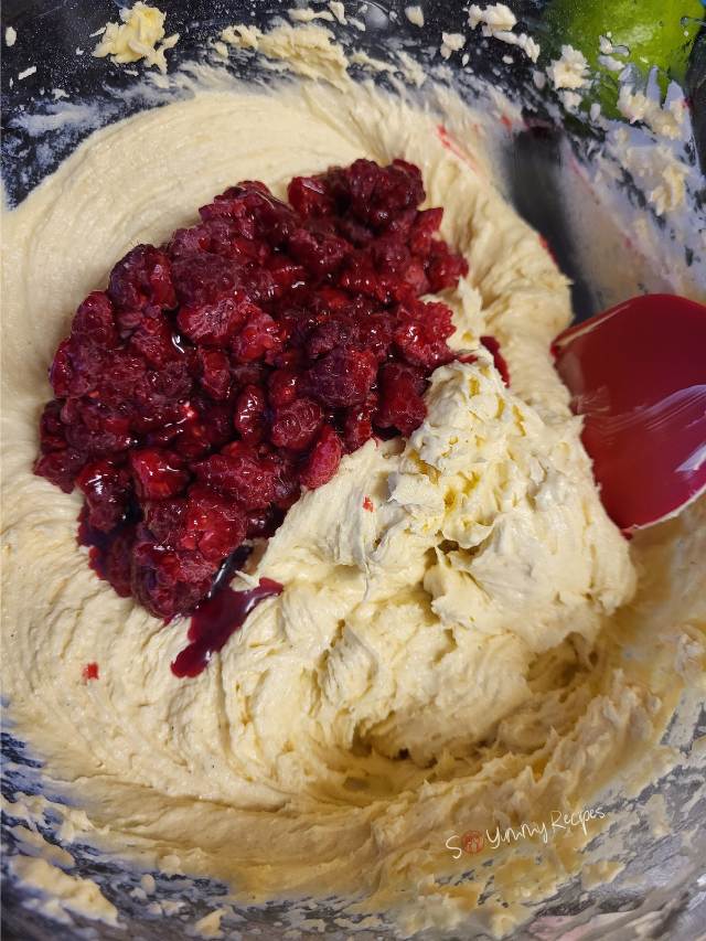Vanilla cupcake batter with raspberries.