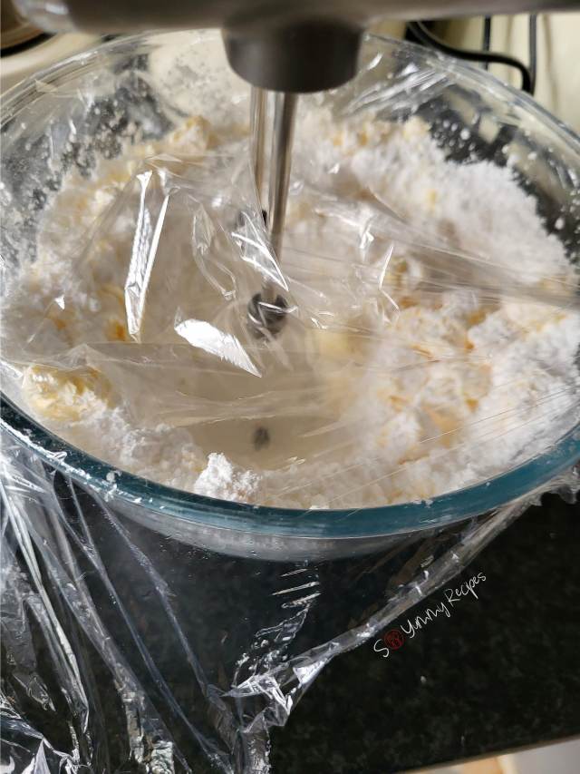 powdered sugar and butter in a mixing bowl covered with cling film.