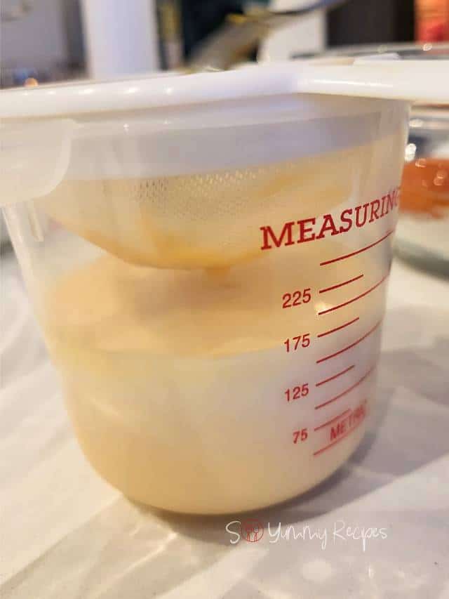 Milk mixed with orange juice in a measuring jar.
