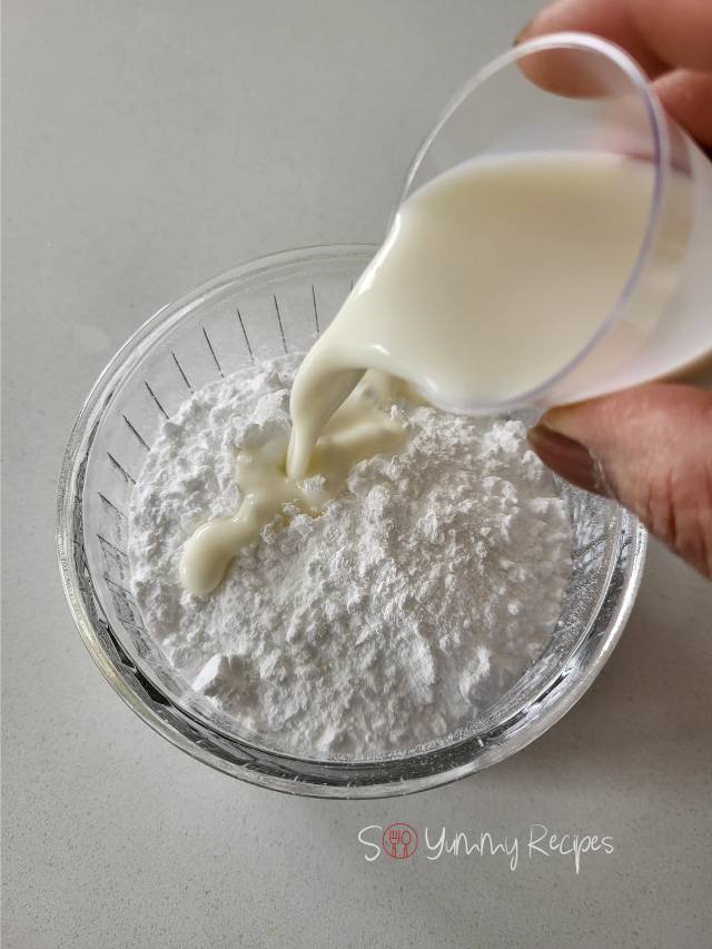 pouring milk into powdered sugar.