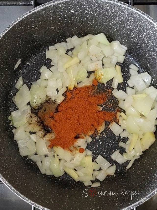 chopped onion, ginger, black pepper and paprika powder in a cooking pan.
