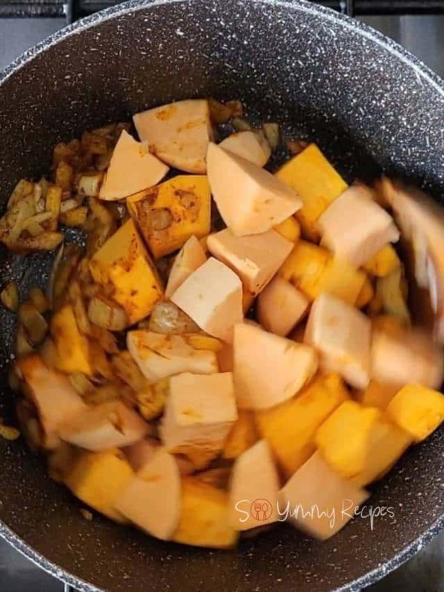 Diced pumpkin and sweet potato chunks in a cooking pan.