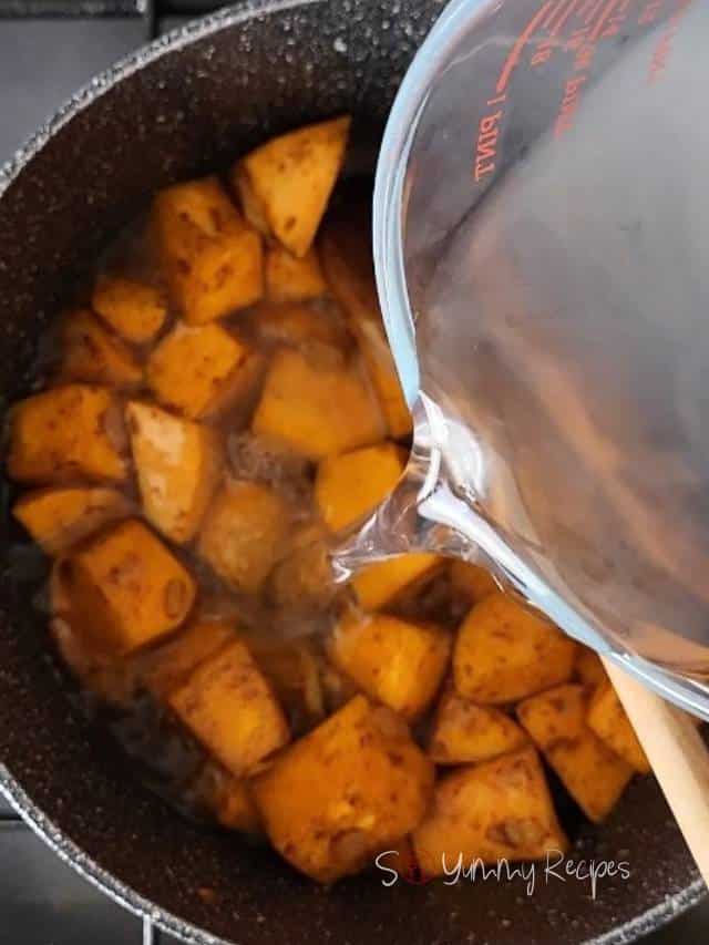 Adding stock to cooked pumpkin.
