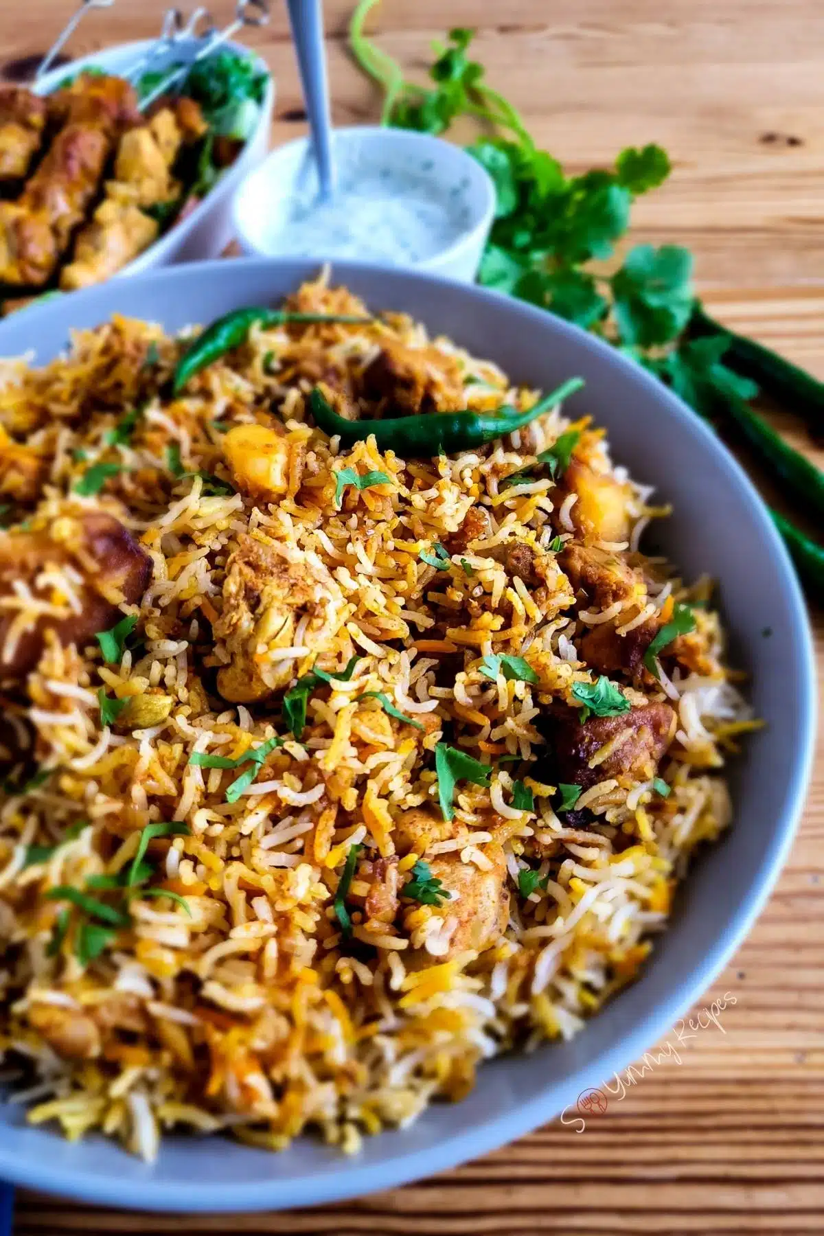 Chicken tikka biryani with chicken tikka and yogurt mint chutney on the side.