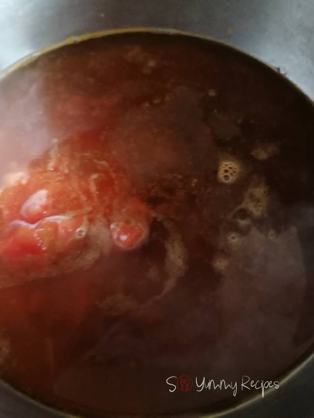 Adding chopped tomatoes in the spice mixture.