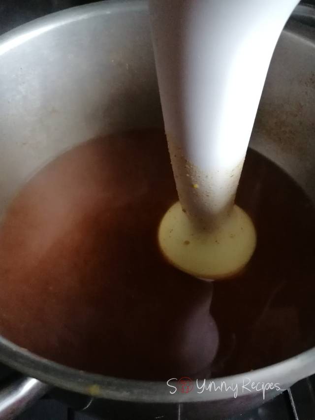 Hand blender in a pan of spices mixture.