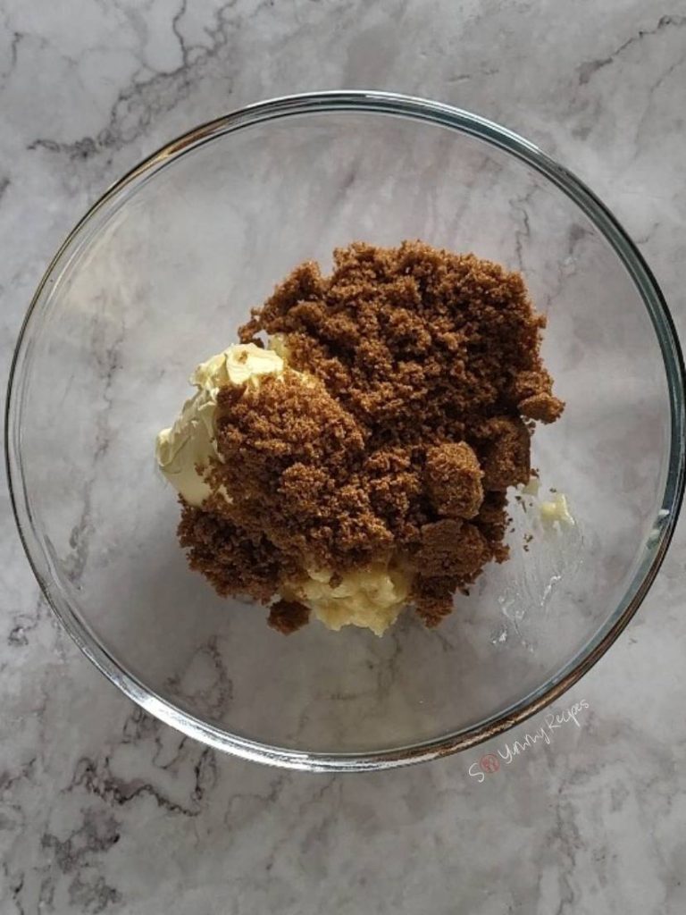 Brown sugar over margarine in a mixing bowl.