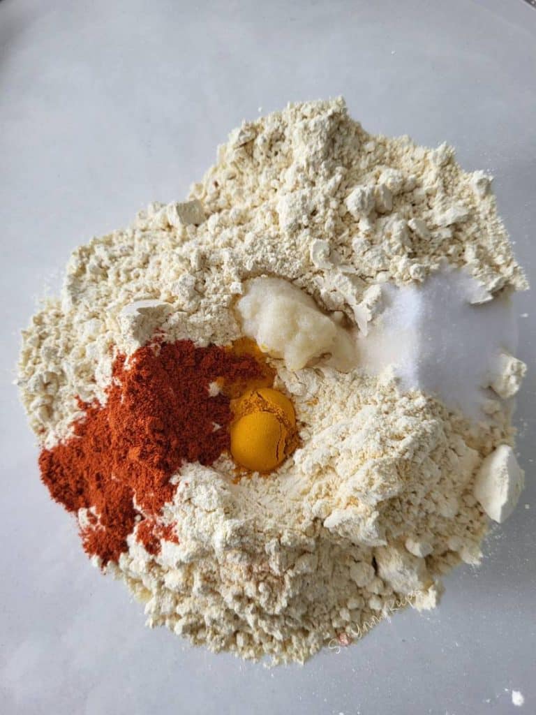 Gram flour, minced garlic, cayenne pepper, turmeric, and salt.