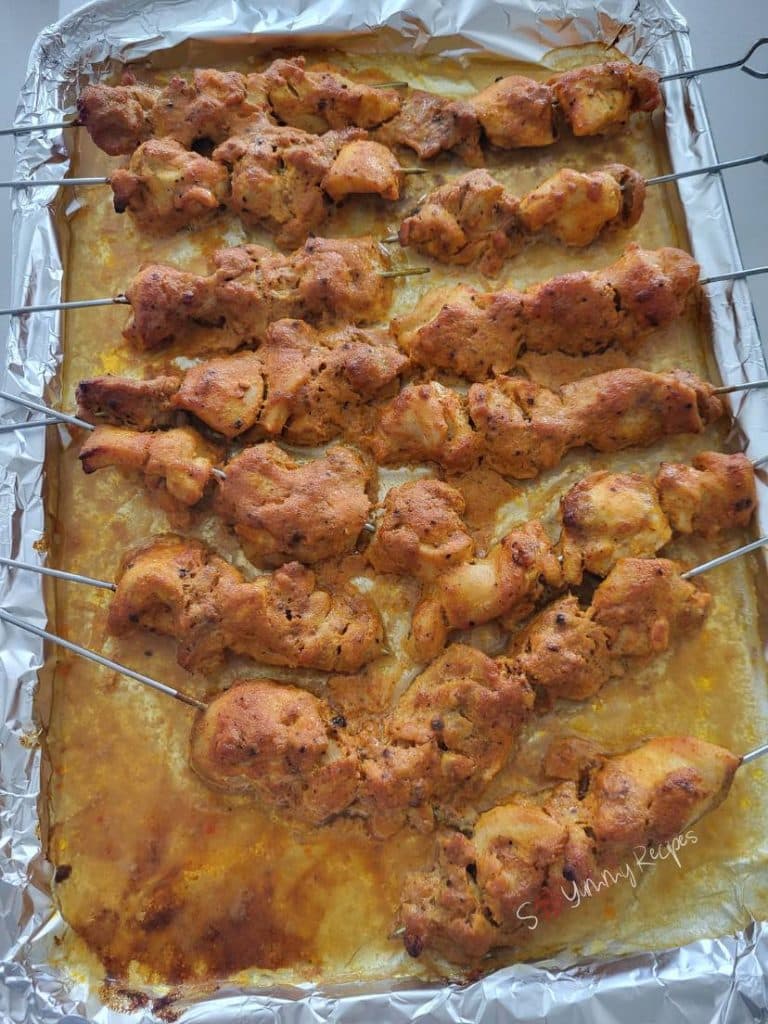 cooked chicken tikka kebabs on a baking tray.