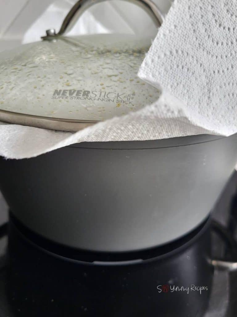 cooking pan with a lid on lined with a kitchen paper.