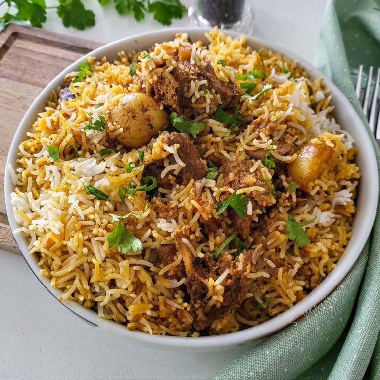 Lamb biryani in white shallow bowl.