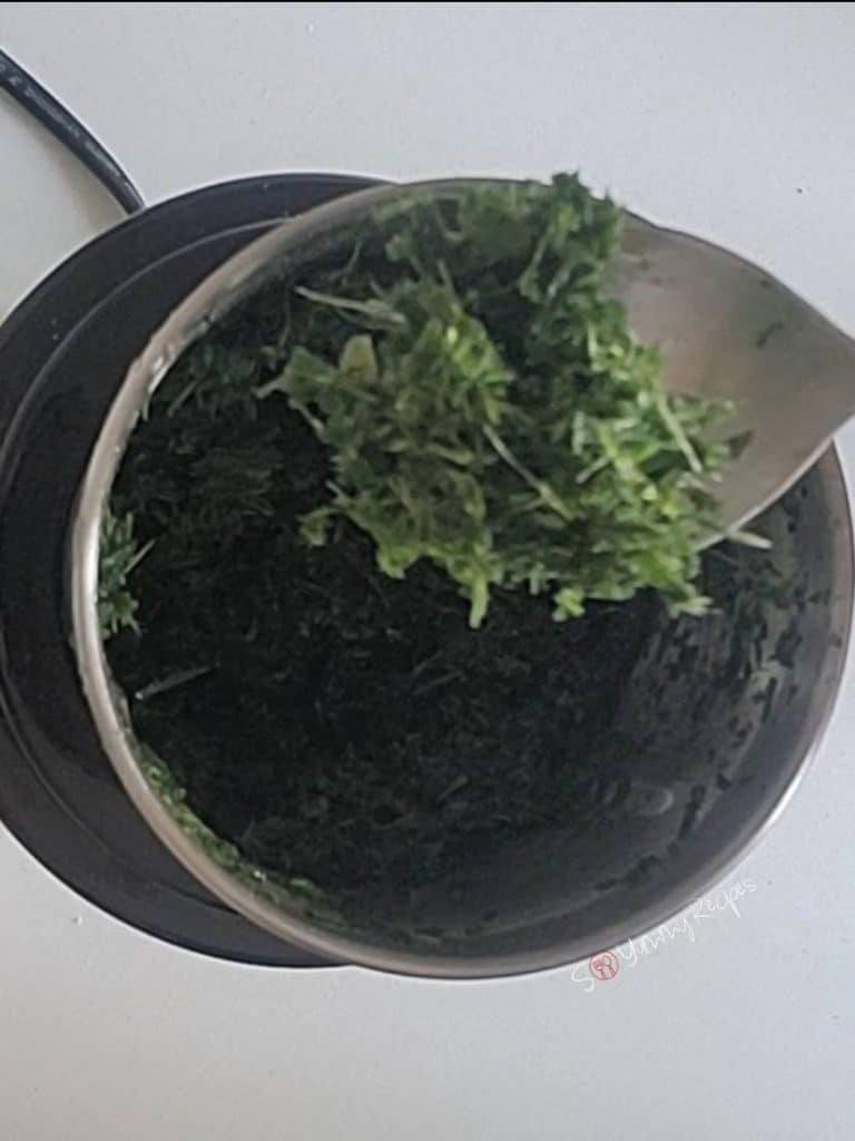 shredded pandan leaves on a teaspoon over a food chopper.