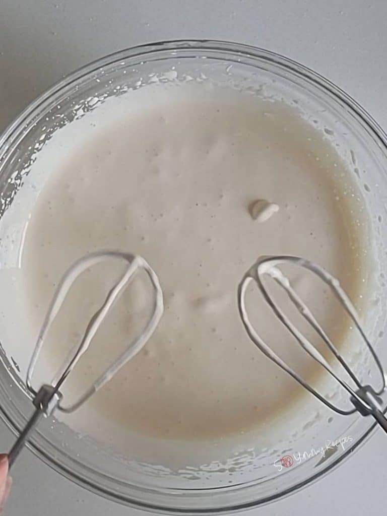 cake batter in a bowl and 2 whisks.