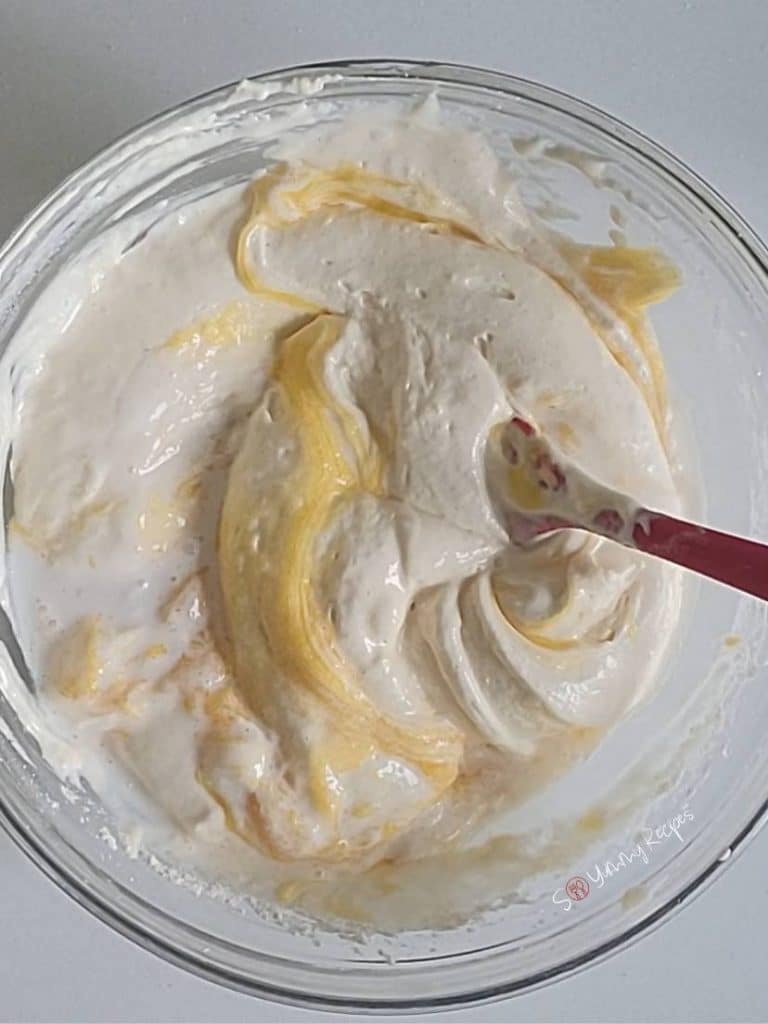 cake batter in a bowl with a spatula.