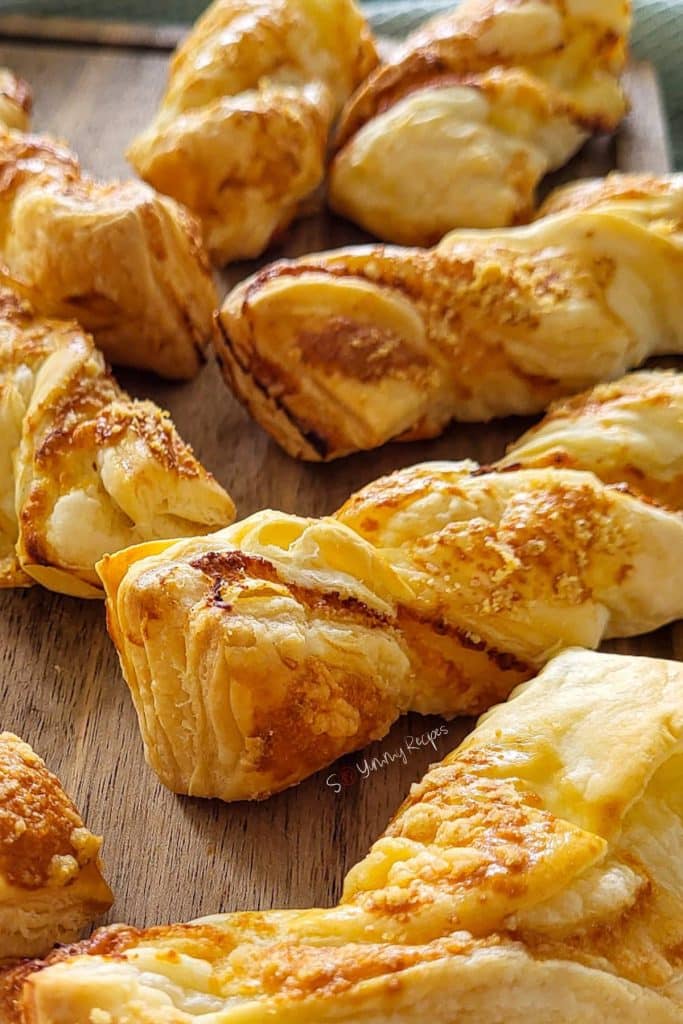 Puff pastries with cheese on a chopping board.