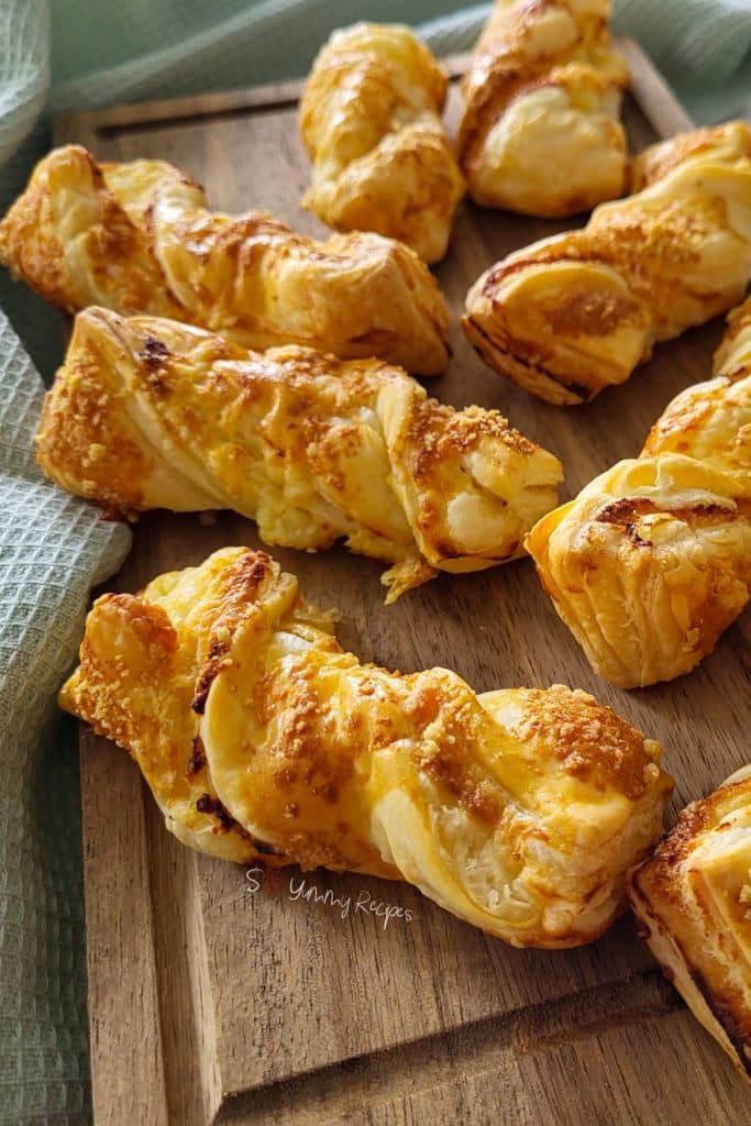 Cheese puff pastries on a chopping board.