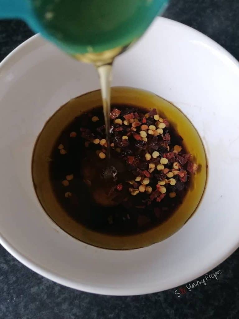 Balsamic dressing in a white bowl with honey drizzling in.