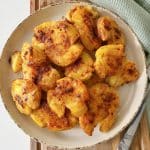 Air fryer smashed potatoes on a round plate.