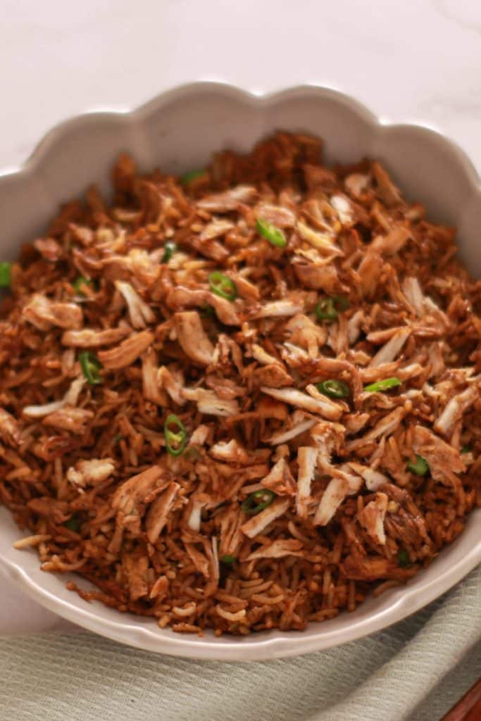A deep plate of chicken fried rice.
