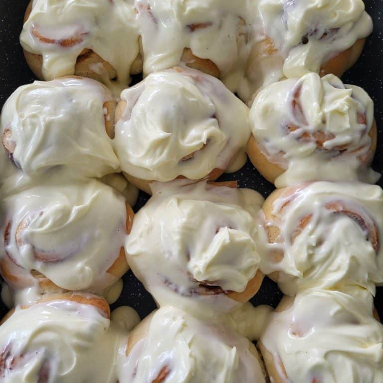 Maple pecan cinnamon rolls frosted with cream cheese frosting.