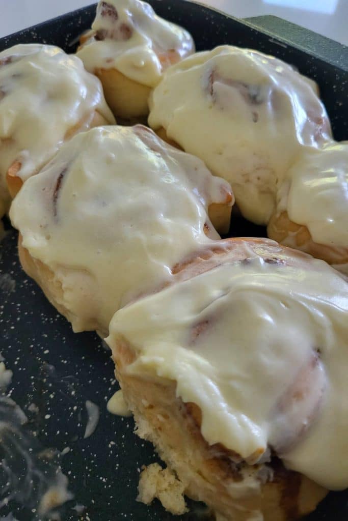 Cinnamon rolls covered with cream cheese frosting.