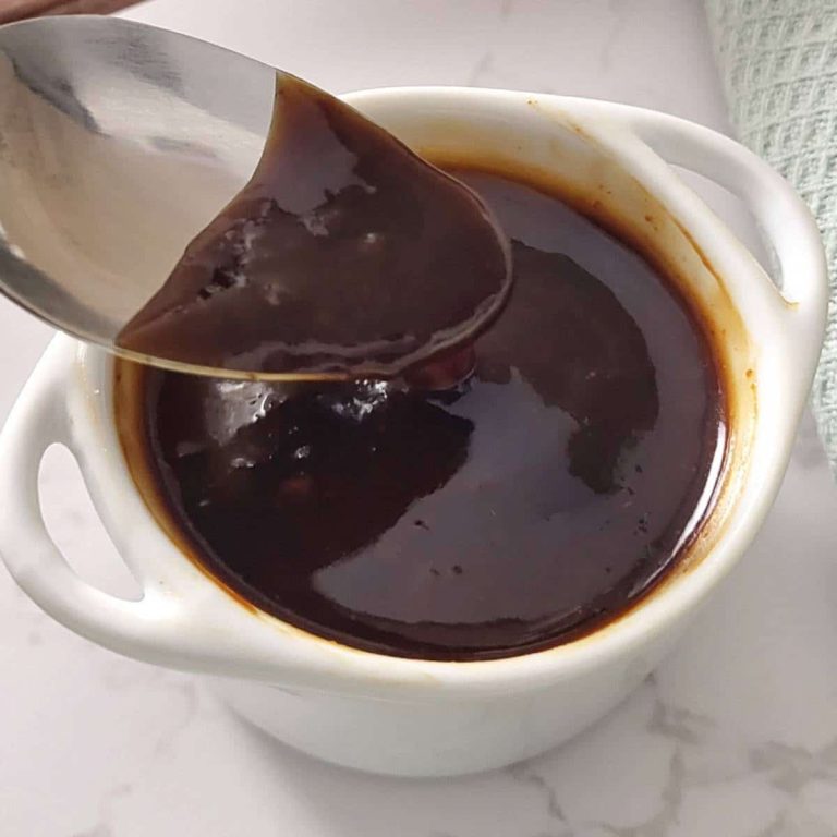 Tonkatsu sauce in a small white bowl with a spoon over it.