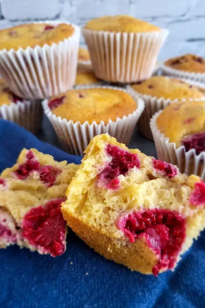 Lemon and raspberry muffins on blue napkin.