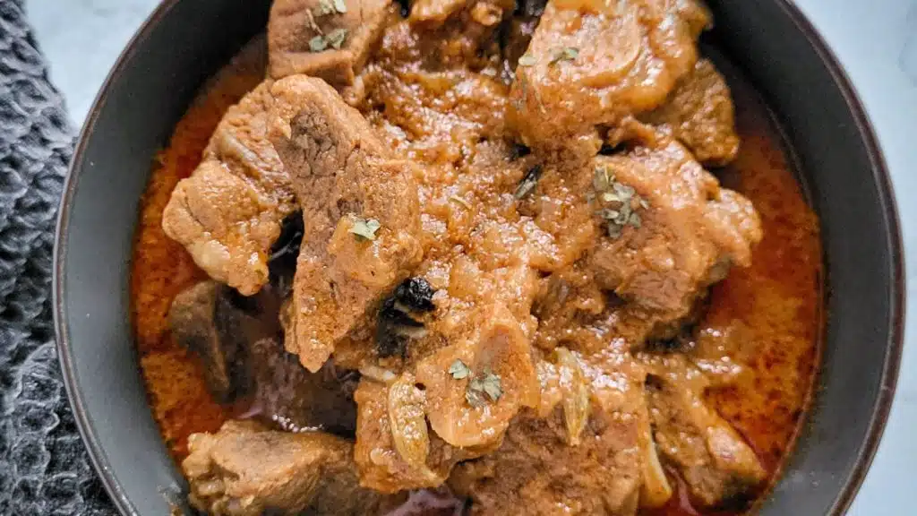 Indian curry, rogan josh in a black bowl.