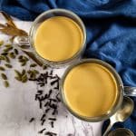 Two cups of chai tea with spices around.