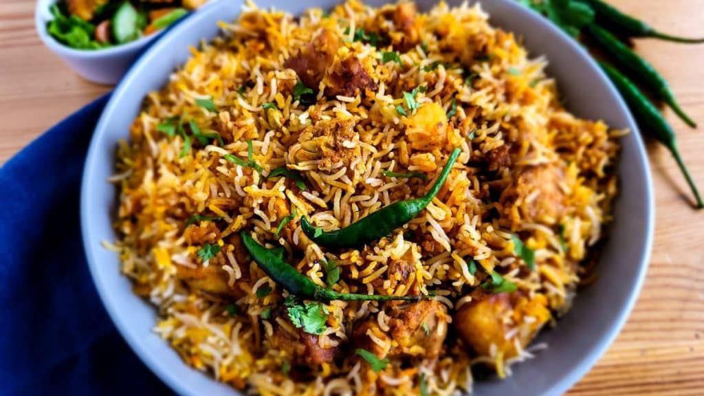 Chicken tikka biryani on a round deep plate.
