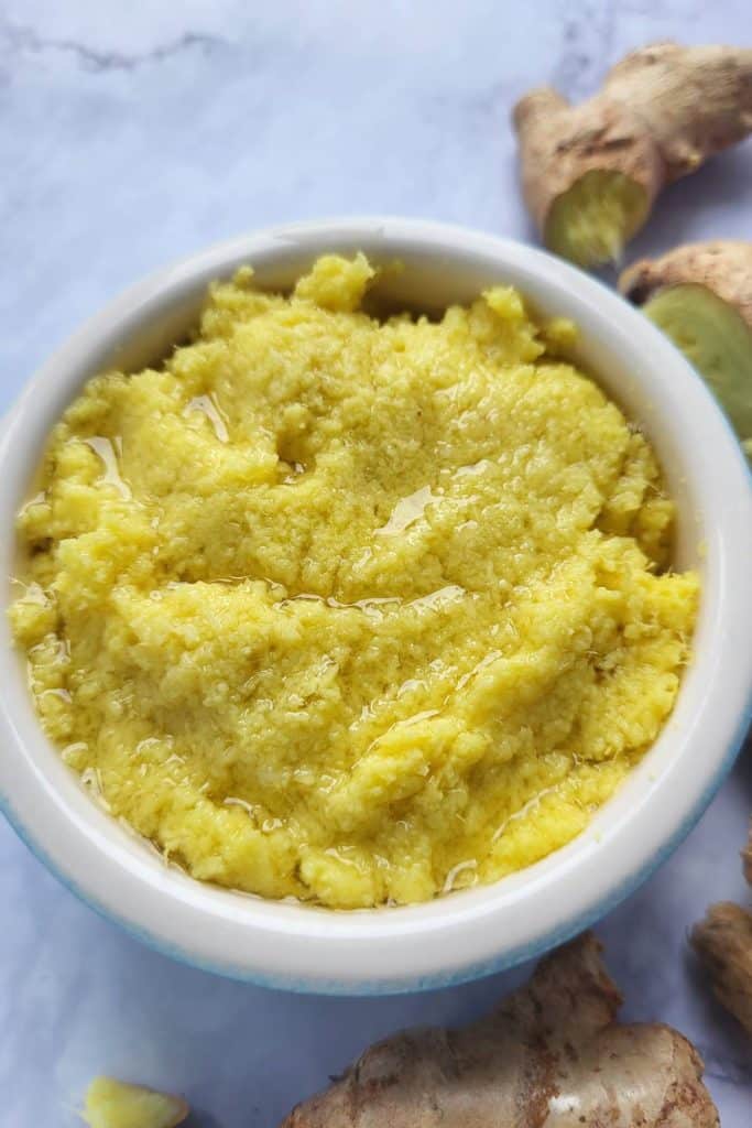 Freshly ground ginger in a small white bowl. 