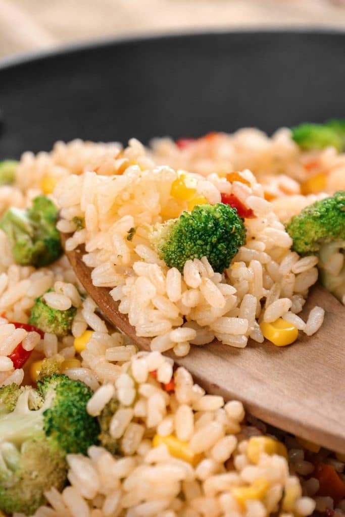 Fried rice with a wooden slotted spoon.