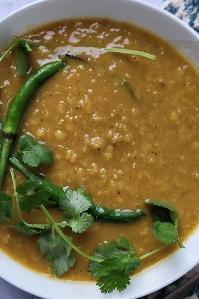 Lentil curry garnished with cilantro and chilies.