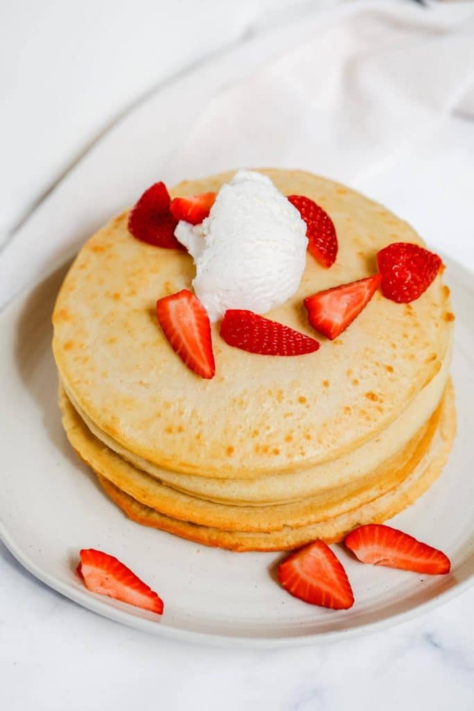 Air fryer pancake topped with cream and strawberries.