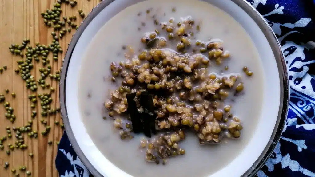 A bowl of Bubur Kacang Hijau with some mung beans and Batik napkin in the background.